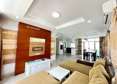 Modern living room with a wall-mounted TV and comfortable seating