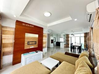 Modern living room with a wall-mounted TV and comfortable seating