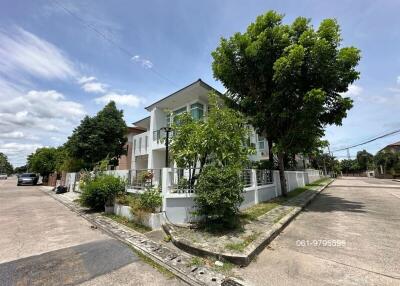 Exterior view of a building on a corner lot with trees and a blue sky.