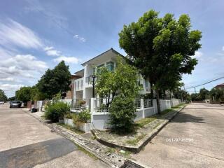 Exterior view of a building on a corner lot with trees and a blue sky.