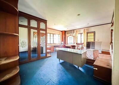 Spacious and well-lit living room with built-in wooden cabinets and large windows