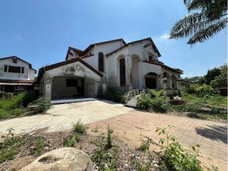 Exterior view of a large multi-story house with a spacious driveway