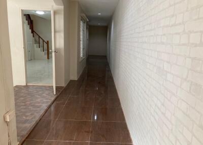 Long hallway with tiles and brick pattern wall