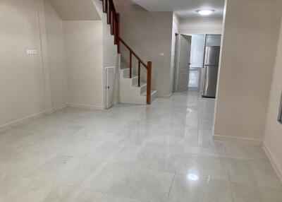 Spacious living area with staircase and view into the kitchen