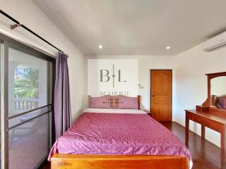 Spacious bedroom with natural light and wooden furniture