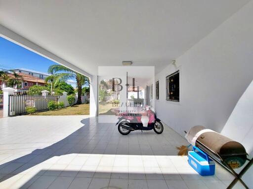 Spacious covered outdoor area with tiled flooring and storage space