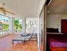 Spacious balcony with lounge chairs and ceiling fan, adjacent to bedroom