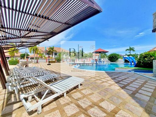 Outdoor pool area with sun loungers and shade structure