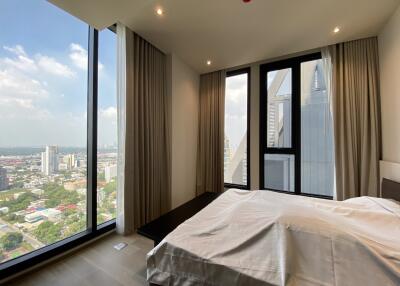 Master bedroom with large windows and a city view