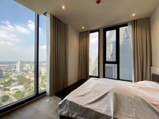 Master bedroom with large windows and a city view