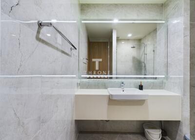 Modern bathroom with marble tiles and a large mirror