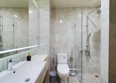 Modern bathroom with a large sink, toilet, and glass-enclosed shower
