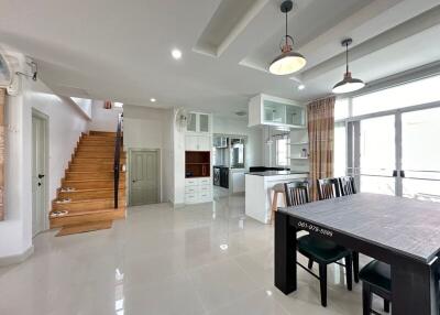 Spacious open-concept living area with kitchen, dining space, and staircase