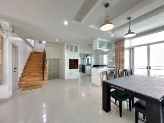 Spacious open-concept living area with kitchen, dining space, and staircase