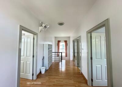 Spacious and bright hallway with multiple doors and a window at the end