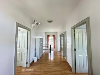 Spacious and bright hallway with multiple doors and a window at the end