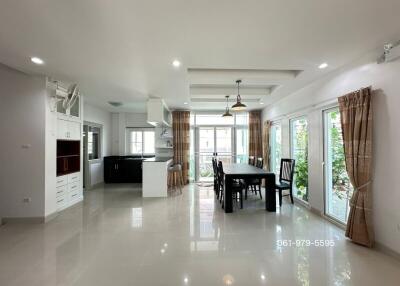 Modern open-plan living and dining area with large windows and a view of the outdoor area