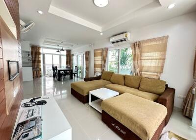 Spacious living room with L-shaped sofa and dining area