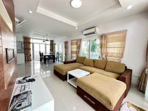 Spacious living room with L-shaped sofa and dining area