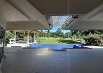 covered patio area with swimming pool and view of garden