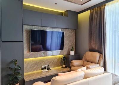 Modern living room with beige leather furniture and a mounted TV