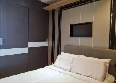 Modern bedroom with fitted wardrobe and wall-mounted TV