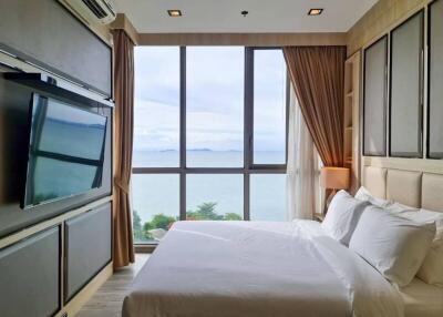 Modern bedroom with large window and ocean view