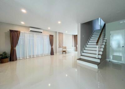 Spacious and modern living area with large windows and staircase