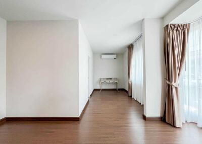 Spacious living room with wooden flooring and large windows