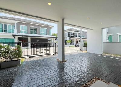 Spacious carport area with view of neighboring houses