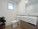 Modern bathroom with a window, sink, and toilet