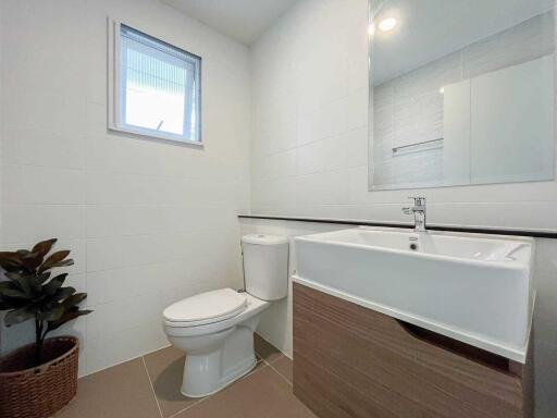 Modern bathroom with a window, sink, and toilet