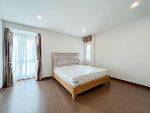 Spacious modern bedroom with a large window and natural lighting