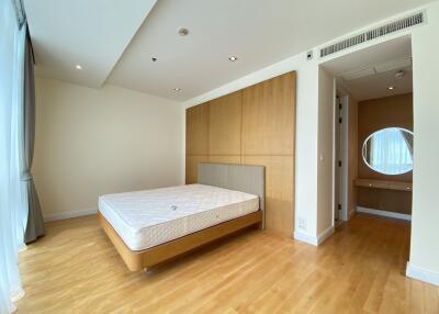 spacious bedroom with wood flooring and large window