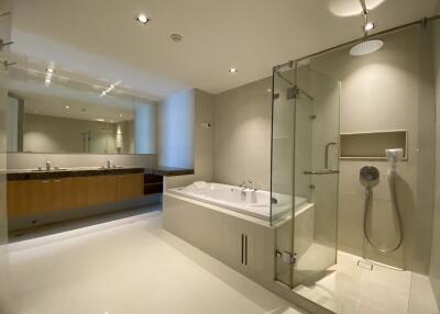 Modern bathroom with large mirror, bathtub, and glass-enclosed shower