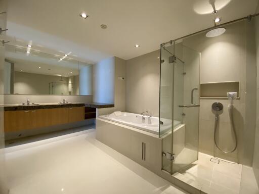 Modern bathroom with large mirror, bathtub, and glass-enclosed shower