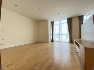 Spacious living room with hardwood floors and large windows