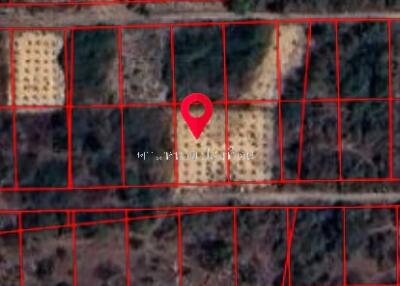 Aerial view of land plot with red boundary lines and a location pin