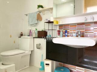 Modern bathroom with white fixtures and colorful tile backsplash