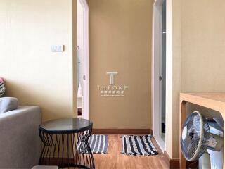 View of a hallway from the living area with a side table and fan