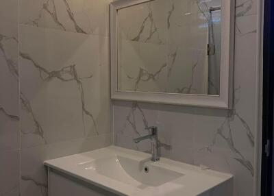 Modern bathroom with marble tiles and a vanity mirror