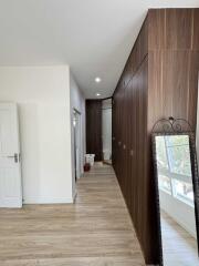 Spacious hallway with wooden flooring and built-in wooden cabinets