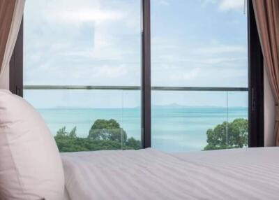 Bedroom with ocean view and glass door balcony