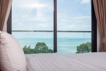 Bedroom with ocean view and glass door balcony