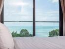 Bedroom with ocean view and glass door balcony