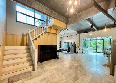 Spacious open-plan living room with modern lighting and large windows