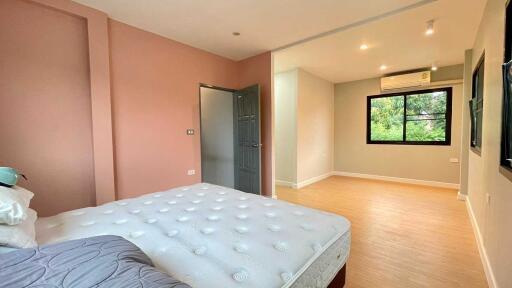 Spacious bedroom with adjoining area and large window