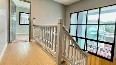 Bright hallway with wooden flooring and large windows