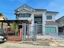 Front view of a modern two-story house with gated driveway