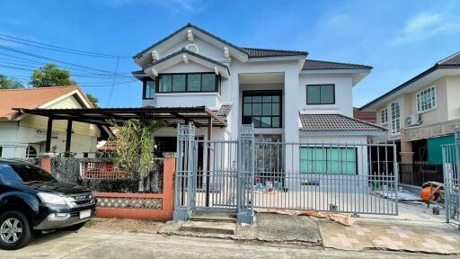 Front view of a modern two-story house with gated driveway